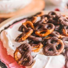 Cranberry pie topped with whipped cream and chocolate covered pretzels.